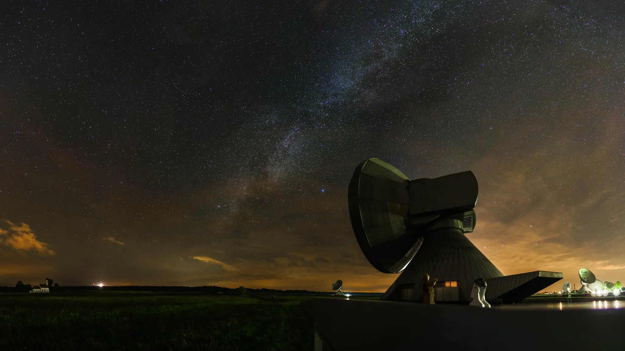 The Milky Way above a large dish antenna at night